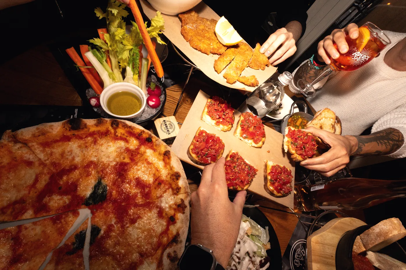 Una tavolata di pizze, tartare e fritti